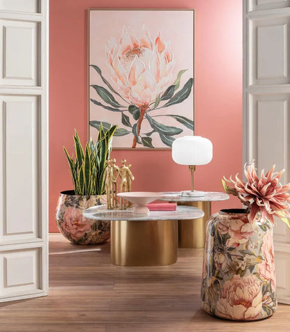 Giara bassa in metallo con decoro floreale rosa in living, accanto ai tavolini