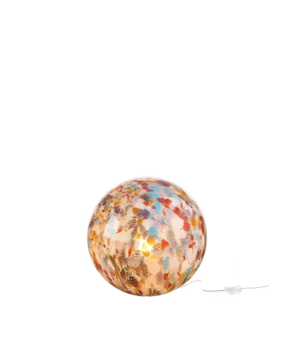 Lampada sfera da tavolo in vetro multicolore accesa su fondo bianco