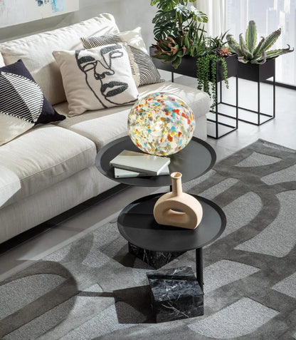 Lampada sfera in vetro multicolore accesa su tavolino nero in salotto